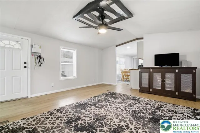 a kitchen with stainless steel appliances granite countertop a refrigerator a stove a sink dishwasher a dining table and chairs with wooden floor