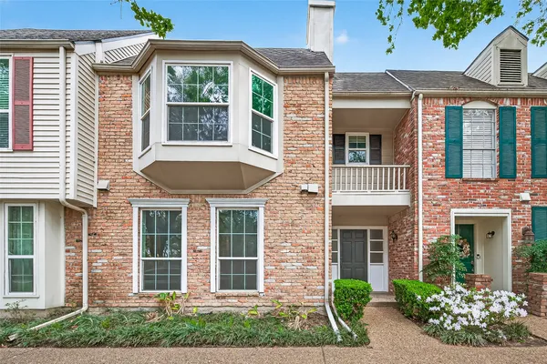 front view of a brick house with a yard