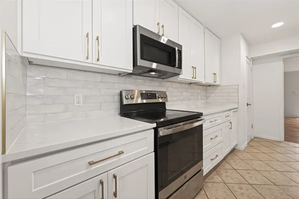 a kitchen with stainless steel appliances granite countertop a sink stove and cabinets