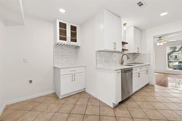 a kitchen with white cabinets and appliances
