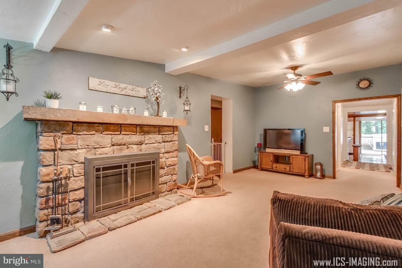 2105 Copenhaffer Road Dover, PA 17315 - Photo 19 of 36 a living room with furniture a fireplace and a ceiling fan