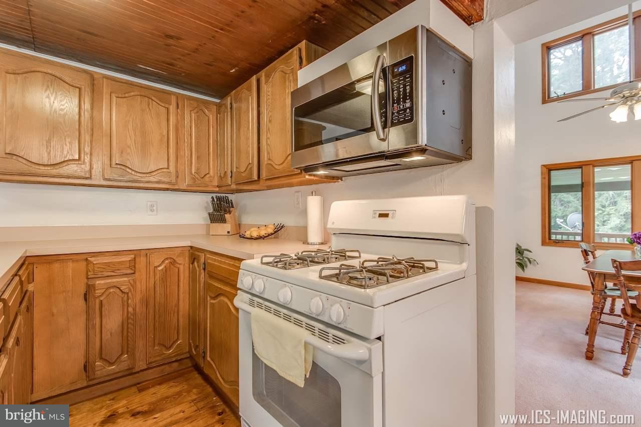2105 Copenhaffer Road Dover, PA 17315 - Photo 22 of 36 a kitchen with stainless steel appliances granite countertop a stove and a microwave with wooden cabinets