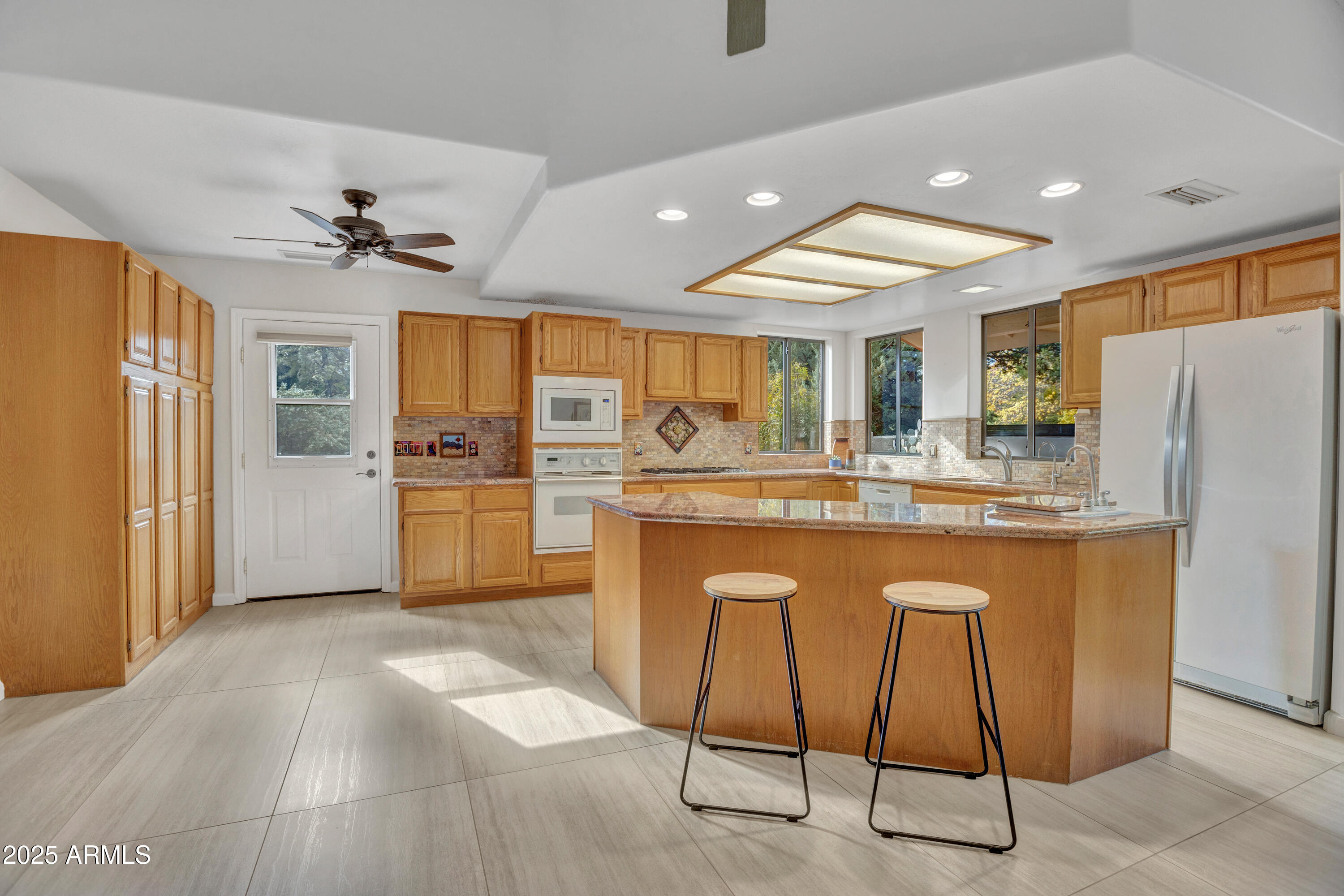 375 Indian Cliffs Road Sedona, AZ 86336 - Photo 10 of 28 a kitchen with stainless steel appliances kitchen island granite countertop a refrigerator and a stove top oven