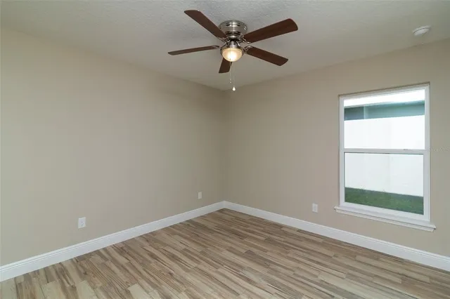 an empty room with a window and wooden floor