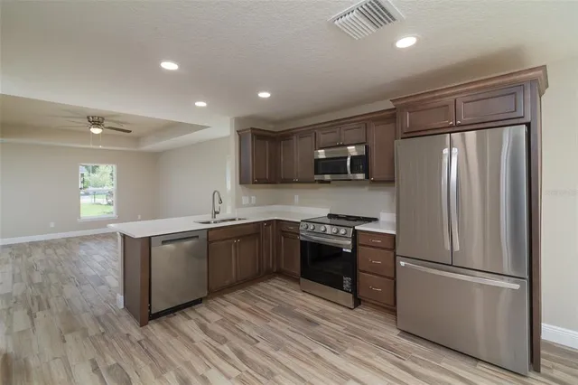 a kitchen with granite countertop a refrigerator stove top oven and sink