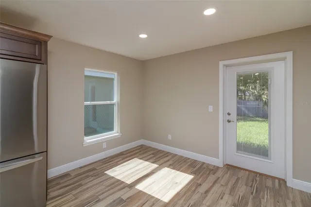 an empty room with wooden floor and a window