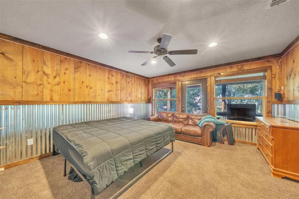 139 Pr-1537 Road Bridgeport, TX 76426 - Photo 39 of 40 a spacious bedroom with a large bed and a chandelier