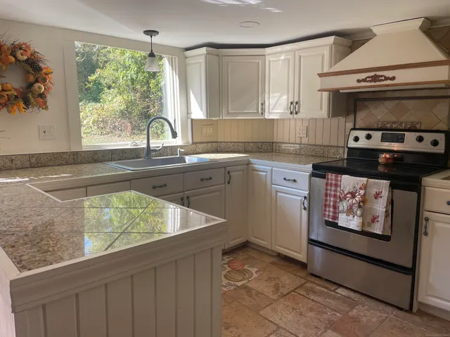 a kitchen with stainless steel appliances a stove a sink and a microwave