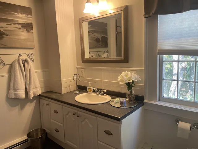 a bathroom with a granite countertop sink and a mirror