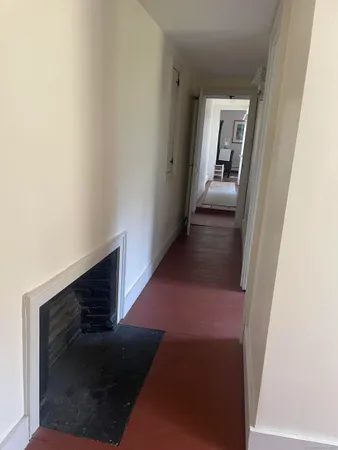a view of a hallway with wooden floor and stairs