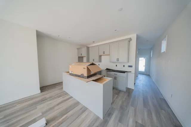 a view of a kitchen with a sink wooden floor and cabinets