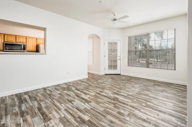 a view of an empty room with a window and wooden floor