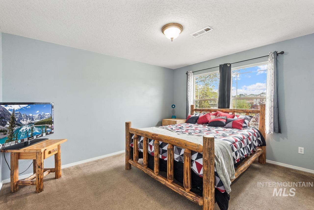 16290 Jewel Way Caldwell, ID 83607 - Photo 24 of 36 Carpeted bedroom featuring a textured ceiling and baseboards