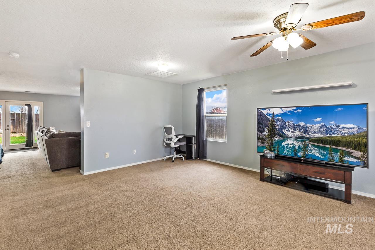 16290 Jewel Way Caldwell, ID 83607 - Photo 8 of 36 Living area with carpet floors, a ceiling fan, a desk, and a textured ceiling