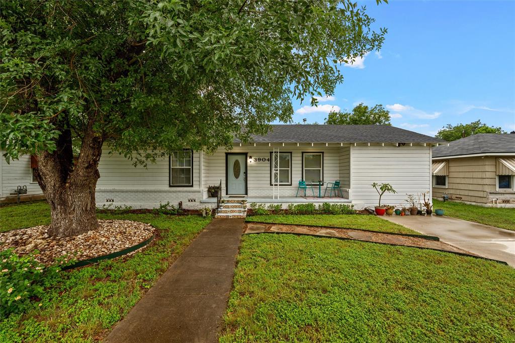 3904 North 21st A Street Waco, TX 76708 - Photo 2 of 26 White siding exterior with a dark shingle roof and a mature shade tree