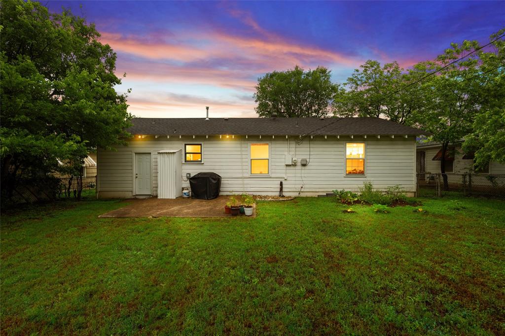 3904 North 21st A Street Waco, TX 76708 - Photo 21 of 26 Expansive grassy backyard featuring a concrete patio, exterior lighting, and mature trees