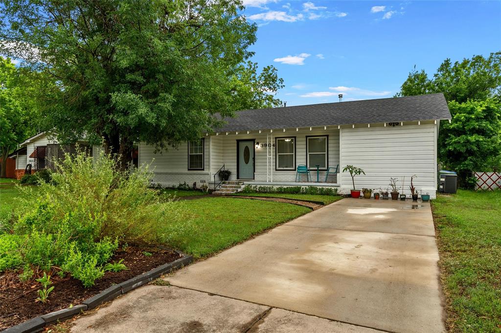3904 North 21st A Street Waco, TX 76708 - Photo 5 of 26 White siding exterior with a dark shingle roof and a concrete driveway