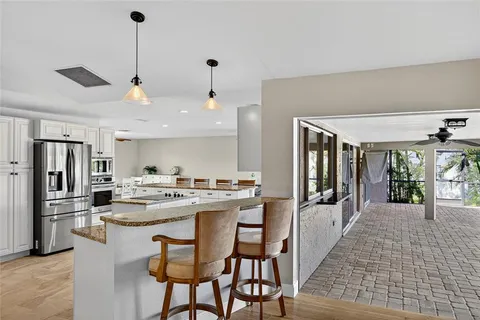a kitchen with refrigerator a stove and chairs