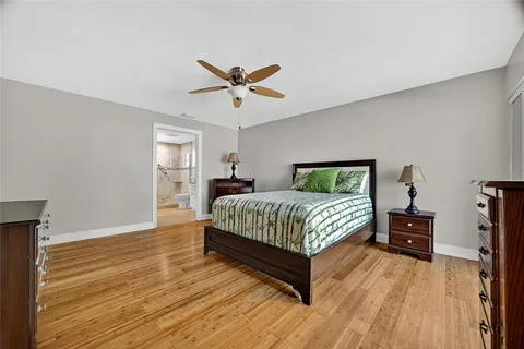 a bedroom with a bed and wooden floor