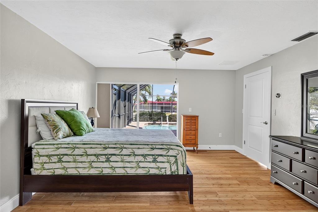 926 Genoa Court Punta Gorda, FL 33950 - Photo 16 of 41 a bedroom with a large bed and a chandelier