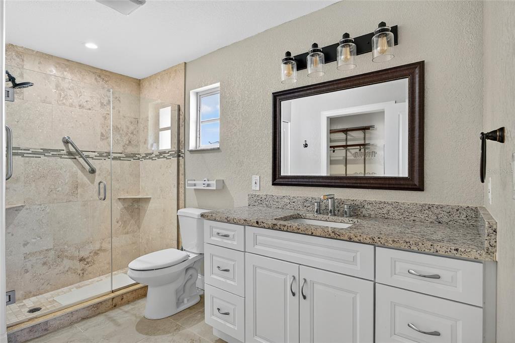 926 Genoa Court Punta Gorda, FL 33950 - Photo 17 of 41 a bathroom with a granite countertop sink mirror vanity and toilet