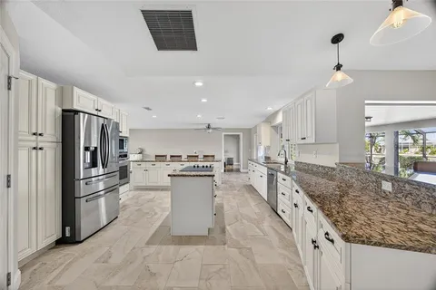 a kitchen with stainless steel appliances granite countertop a sink stove and refrigerator