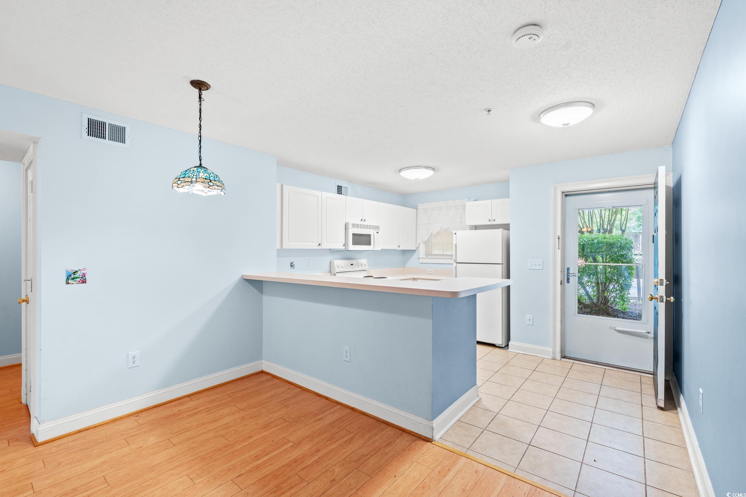 6016 Dick Pond Road, Unit 109 Myrtle Beach, SC 29588 - Photo 11 of 35 Kitchen with white appliances, a peninsula, white