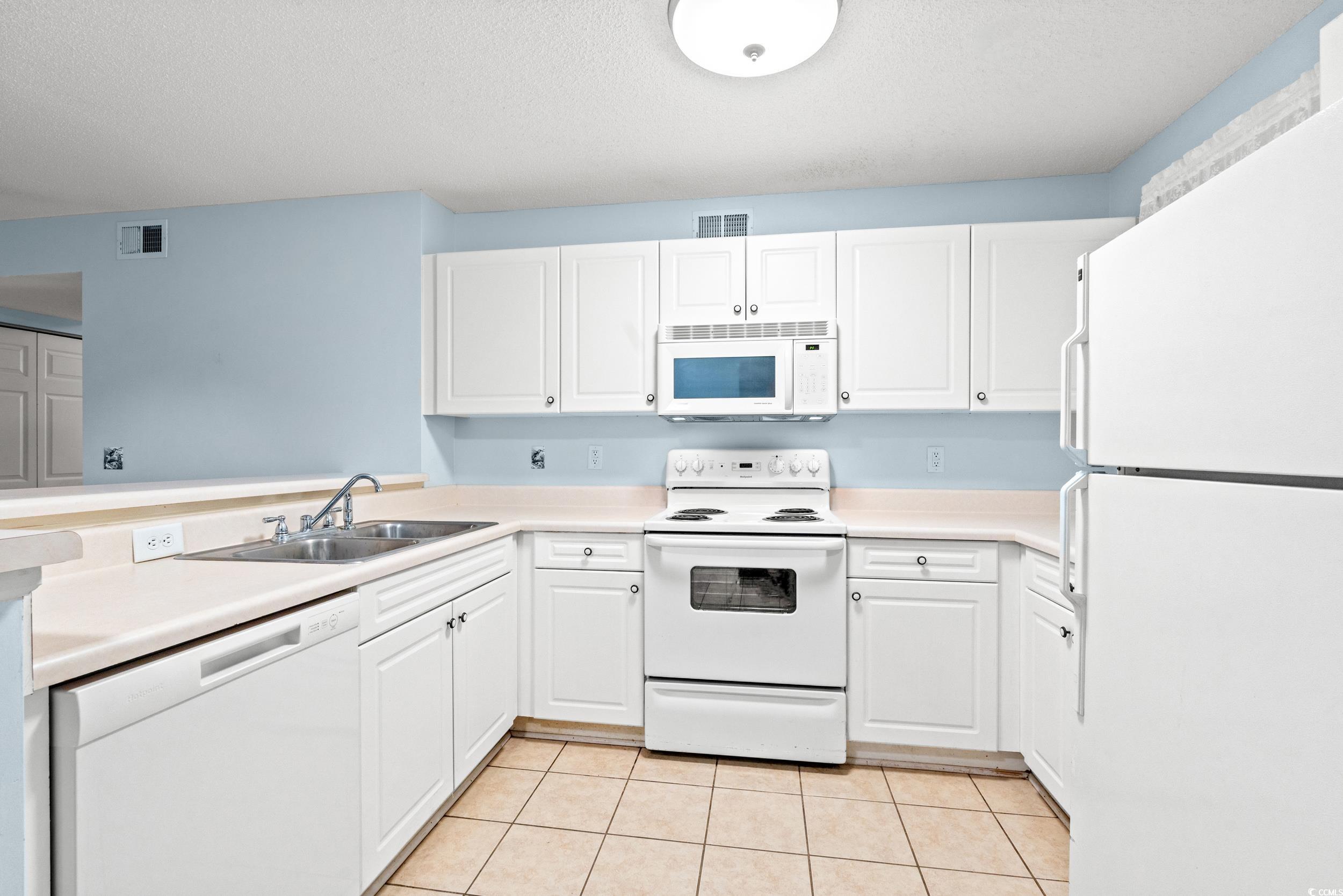 6016 Dick Pond Road, Unit 109 Myrtle Beach, SC 29588 - Photo 13 of 35 Kitchen with white appliances, white cabinets, a s