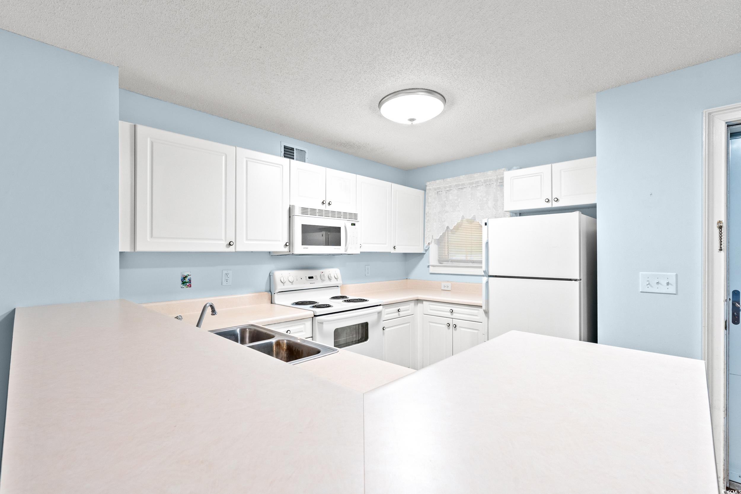 6016 Dick Pond Road, Unit 109 Myrtle Beach, SC 29588 - Photo 14 of 35 Kitchen featuring white appliances, a sink, white