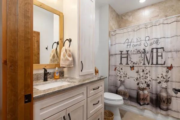 a bathroom with a granite countertop toilet sink and a mirror