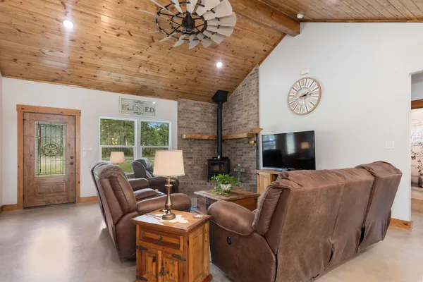 a living room with furniture a large window and a fireplace