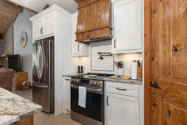 a kitchen with stainless steel appliances granite countertop a stove a refrigerator and a microwave
