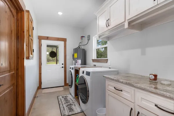a utility room with cabinets washer and dryer