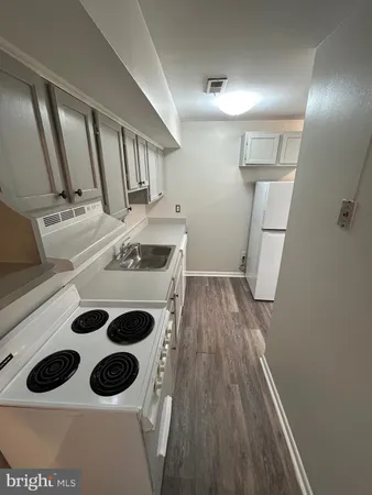 a view of kitchen with a sink and wooden floor