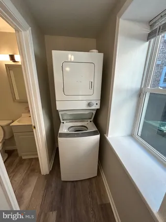 a utility room with wooden floor washer and dryer