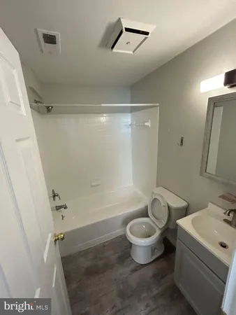 a bathroom with a sink a toilet a mirror and a shower