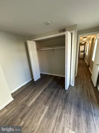 an empty room with wooden floor and door