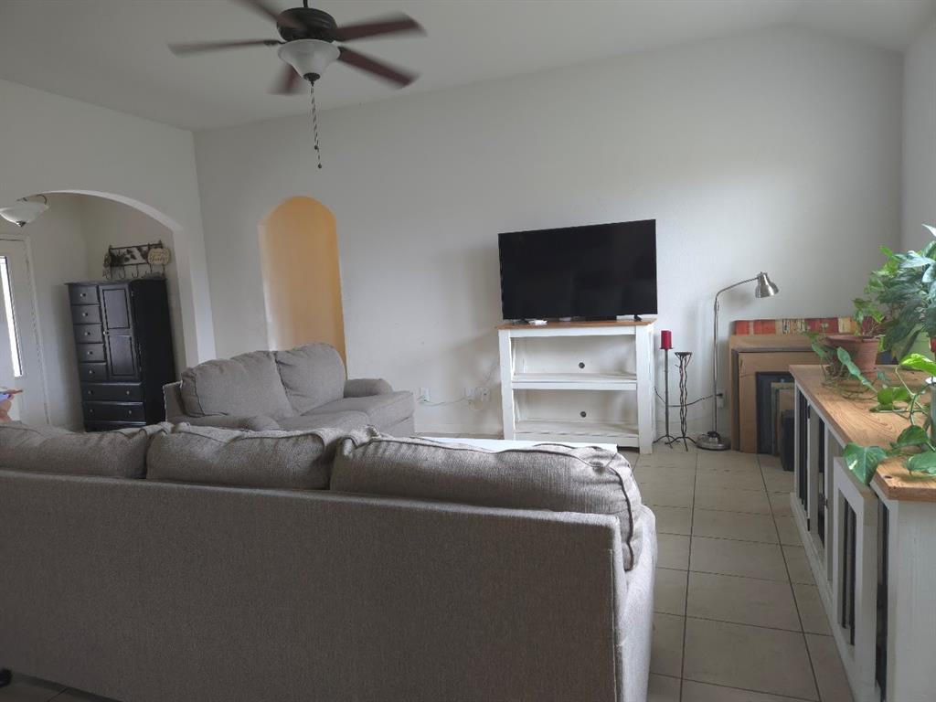 308 Kaylee Way Red Oak, TX 75154 - Photo 7 of 25 Living room featuring a ceiling fan, light tile patterned flooring, and arched walkways