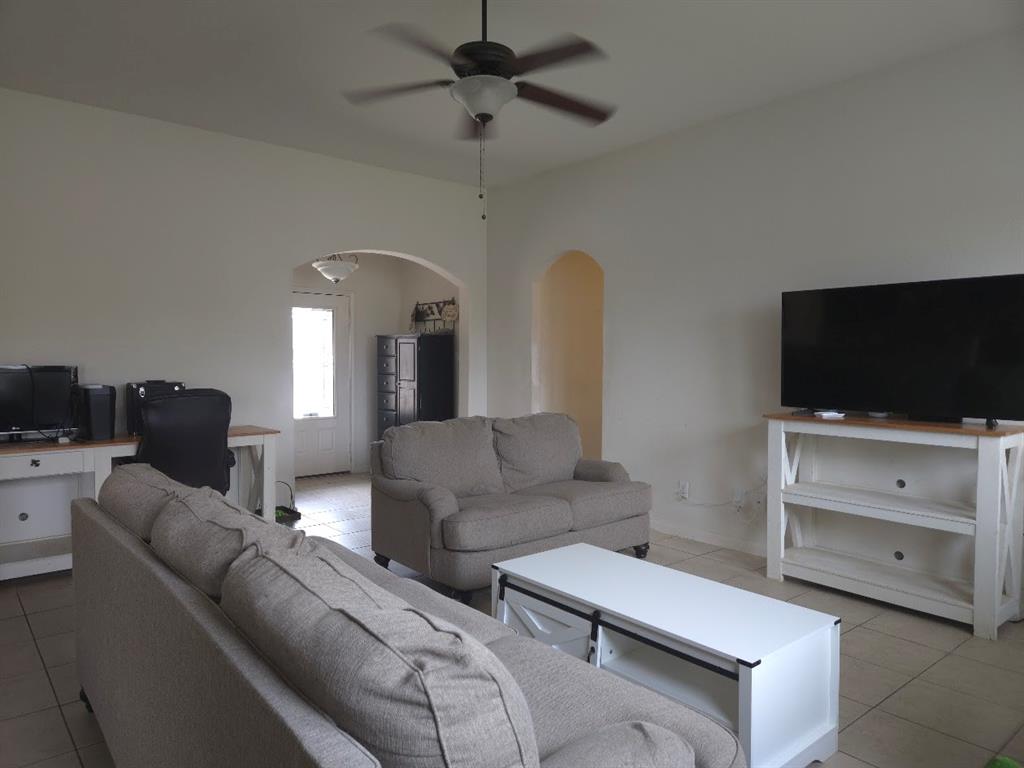 308 Kaylee Way Red Oak, TX 75154 - Photo 8 of 25 Living area with light tile patterned flooring, a desk, ceiling fan, and arched walkways