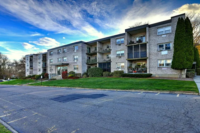 a view of a big building with a big yard and large trees