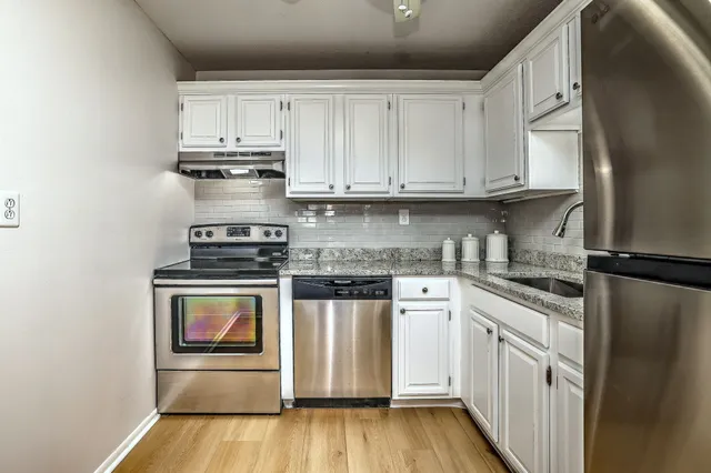 a kitchen with stainless steel appliances granite countertop a refrigerator sink and cabinets