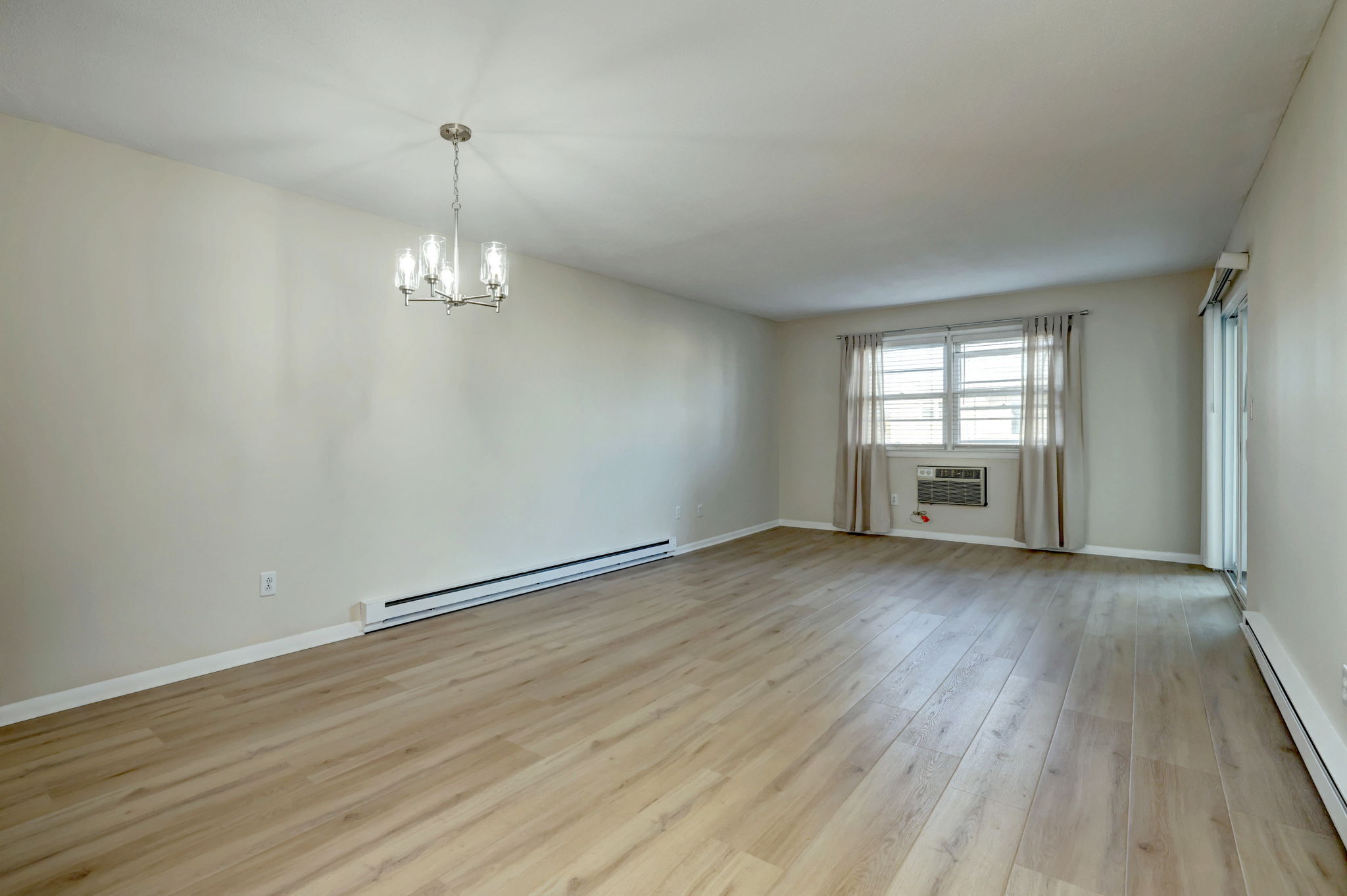 308 Meadowside Road, Unit 202 Milford, CT 06460 - Photo 5 of 40 an empty room with wooden floor and windows