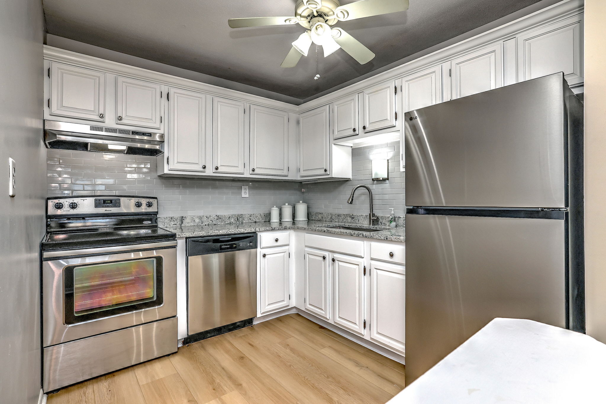 308 Meadowside Road, Unit 202 Milford, CT 06460 - Photo 6 of 40 a kitchen with stainless steel appliances granite countertop a refrigerator a stove a sink and white cabinets