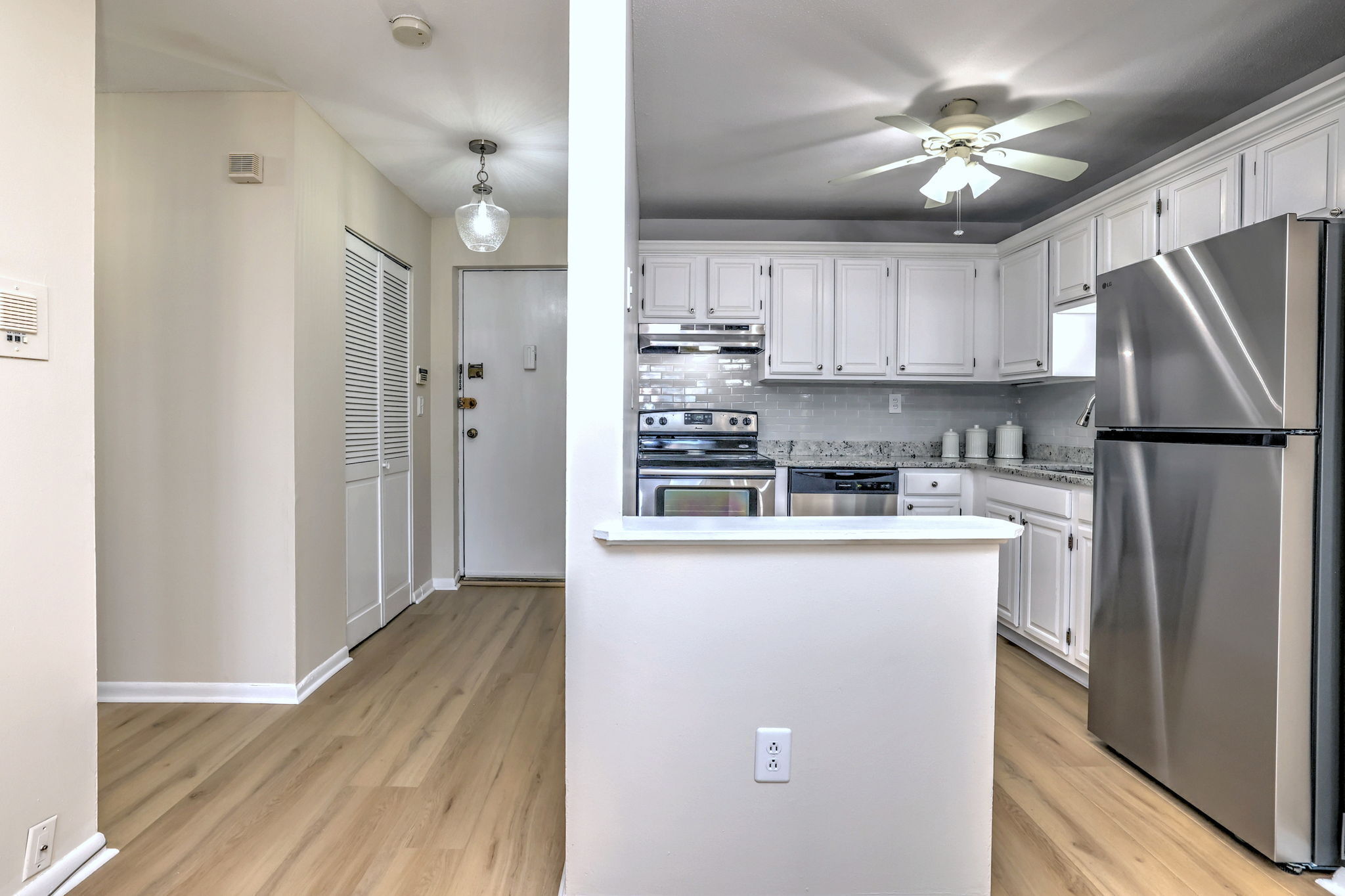 308 Meadowside Road, Unit 202 Milford, CT 06460 - Photo 7 of 40 a kitchen with stainless steel appliances granite countertop a refrigerator a stove a sink and white cabinets with wooden floor