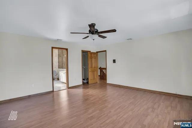 a view of a hallway with wooden floor and closet