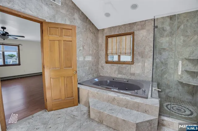 an empty room with wooden floor and a ceiling fan