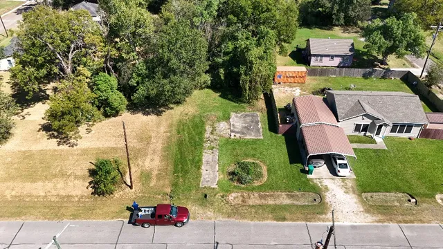 an aerial view of a house with a garden and lake view