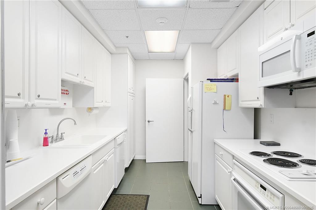 8600 South Ocean Drive, Unit 306 Jensen Beach, FL 34957 - Photo 62 of 76 a kitchen with a sink and white cabinets