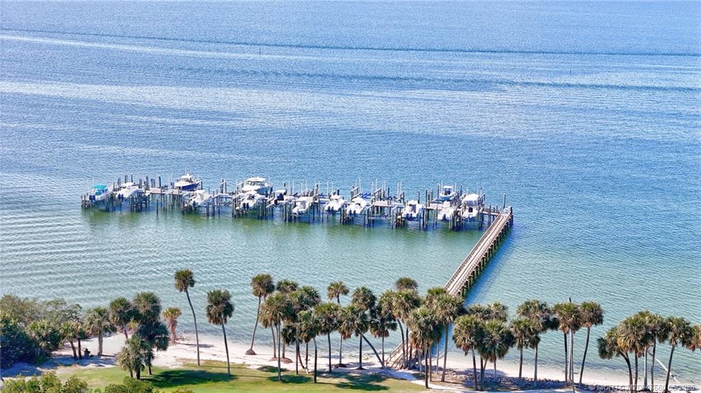 8600 South Ocean Drive, Unit 306 Jensen Beach, FL 34957 - Photo 69 of 76 a view of a lake with a lawn chairs and palm trees