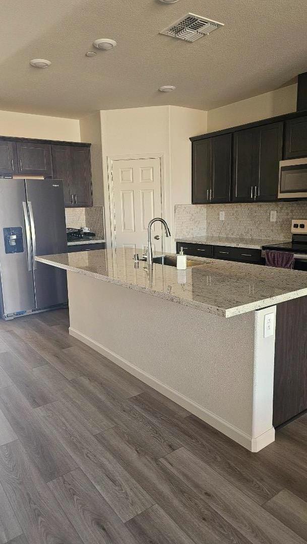 2865 Bering Street Manteca, CA 95337 - Photo 6 of 11 a kitchen with granite countertop a stove and a wooden floors